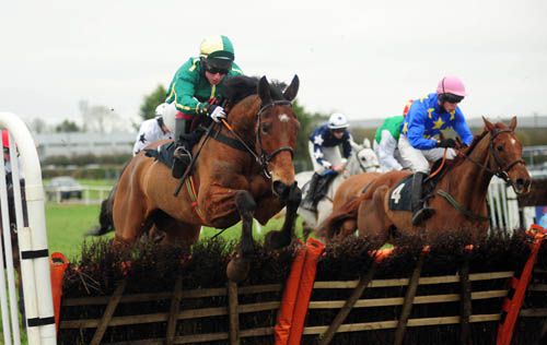 Betterthanalright (green colours) jumps a hurdle<br>on his way to winning the handicap hurdle