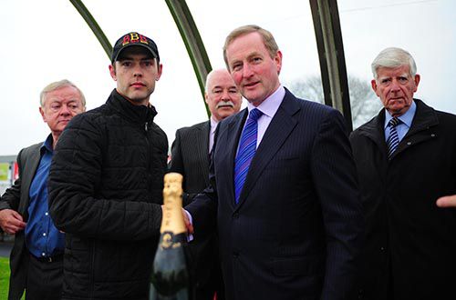 Trainer Johnny Levins receives his prize from An Taoiseach Enda Kenny after Noble Call's win