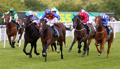 Es Que Love (centre, stars on body and cap) winning at Goodwood
