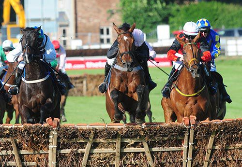 Shake The Bucket (centre) jumps the last with By The Banks (left) and Jack Slade (right)