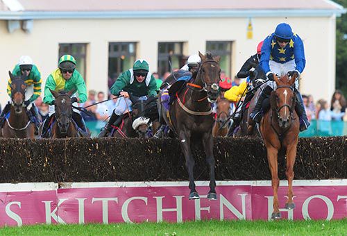 Carole Rose jumps the final fence alongside a loose horse