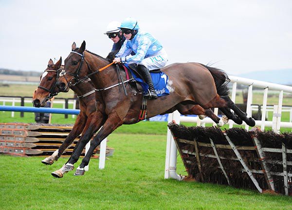 Minella Melody (Rachael Blackmore) holds a slight edge over Colreevy (far side) at the last