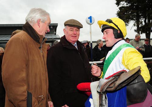 Jockey Paddy Flood debriefs Canaly's trainer Dessie Hughes (left) and owner Michael Moore