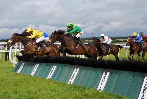 Katie's Jem and Keith Clarke, green, jump   into contention at the last