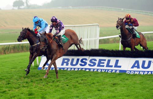 Definite Ridge (purple) jumps a hurdle on his way to victory under Niall Madden