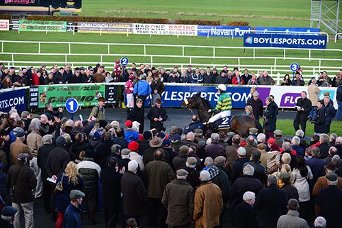 Racegoers crowd around the parade ring to welcome back in Minella Foru and Tony McCoy