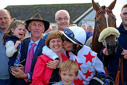Rory Cleary gives his mother Kathleen a kiss with his father Tom (suit) alongside