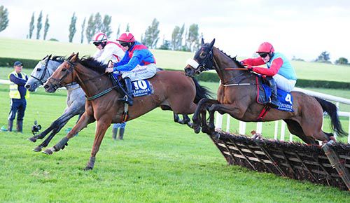 Rachael Blackmore (blue and red) on Oisin James jumps the last with Danali, followed by Urtheoneiwant 