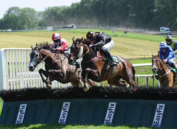 The King Of Brega (centre) jumps to the front at the last for Dylan Robinson