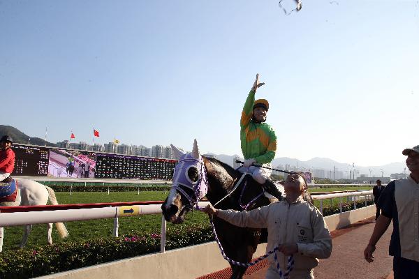 Jockey Keith Yeung throws his goggles to the crowd after winning