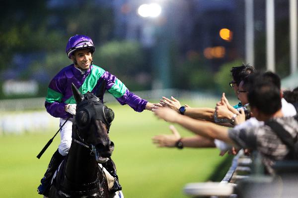 Joao Moreira celebrates with fans on the track after winning the opening race on the David Hall-trained Penzance