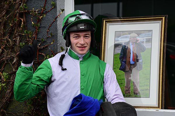 David Mullins stands in front of a picture of the late Pierce Molony