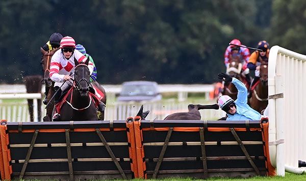Rathnaleen Kal and Gary Noonan(white red) face the last hurdle to win the Kanturk Handicap Hurdle.