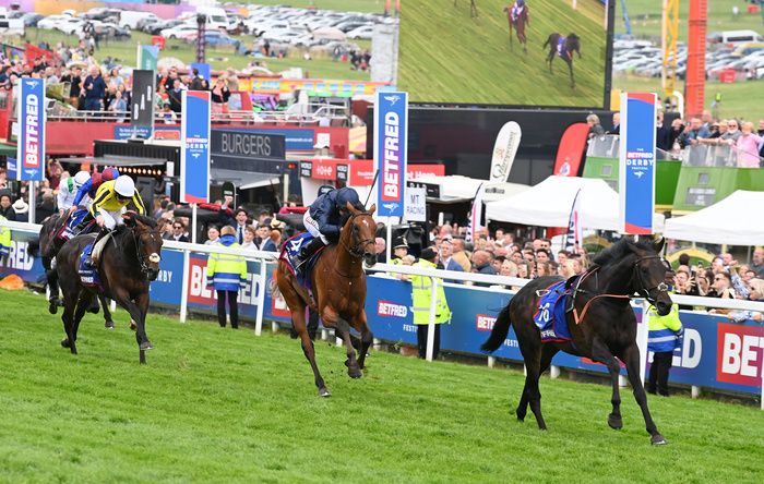 City Of Troy and Ryan Moore are led home by the riderless Voyage. 