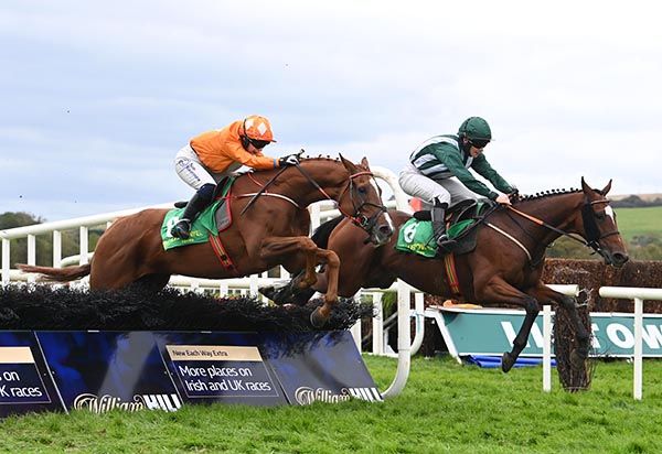 Ollie La Ba Ba (orange) jumps the last with Half A Chance  