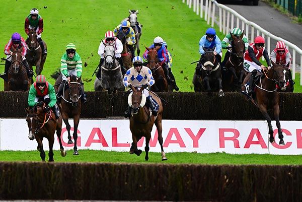 Tell Us This and Conor Stone Walsh (red cap on right) jump the second last fence 